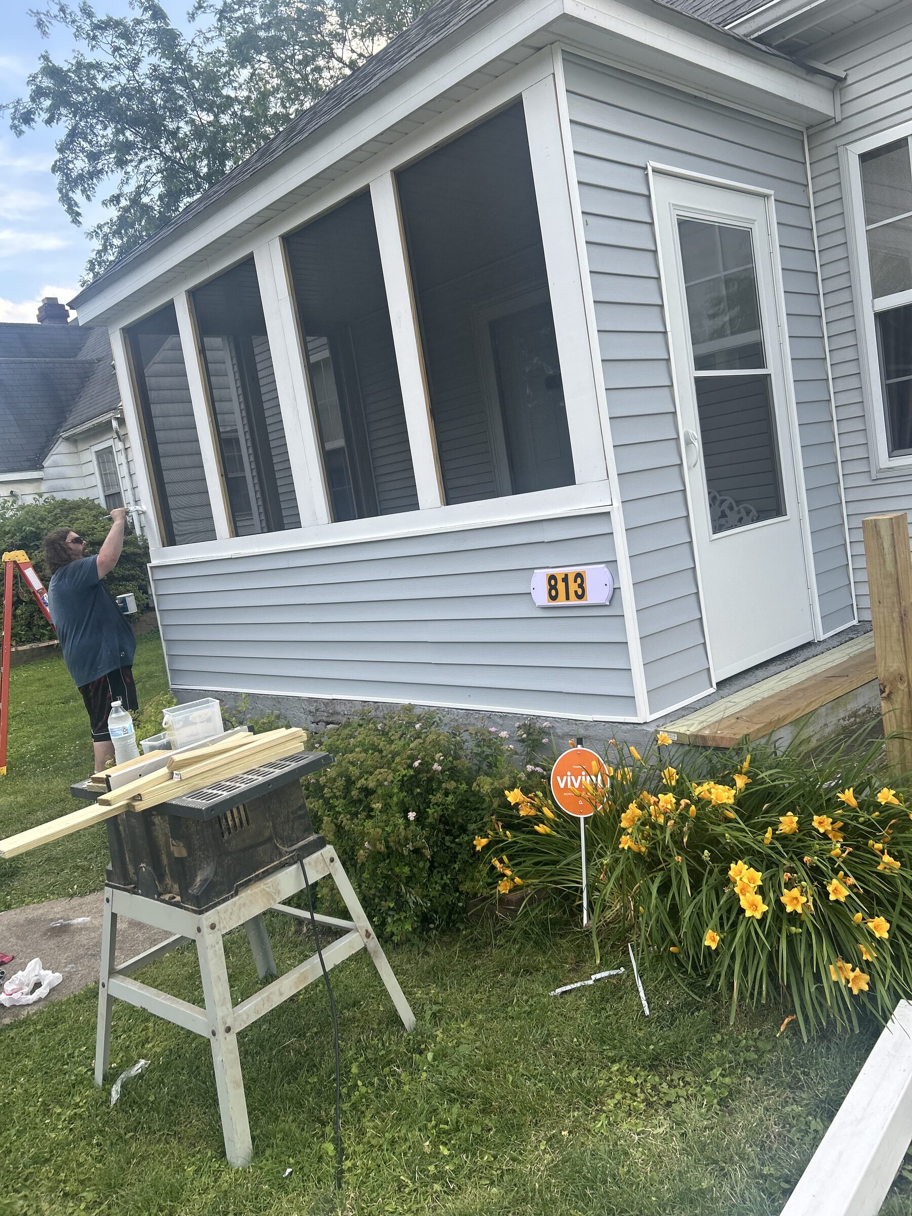 L&S Construction crew finishing a newly closed-in screened porch with new siding