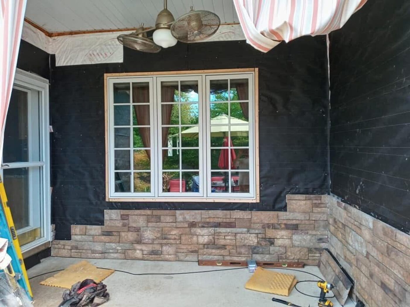 Porch wall before stone accent was installed, with house wrap and bare window